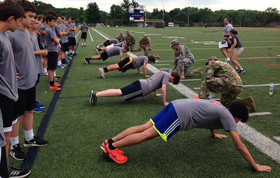Staff Sgt. Kahle Wright and other Soldiers with Company A, Recruit Sustainment Program, Ohio Army National Guard Recruiting and Retention Battalion, grade pushups during an Army Physical Fitness Test administered to members of the Bishop Watterson High School boys soccer team.