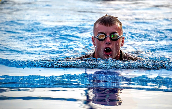 Spc. Andrew Draving swims in full uniform during testing.