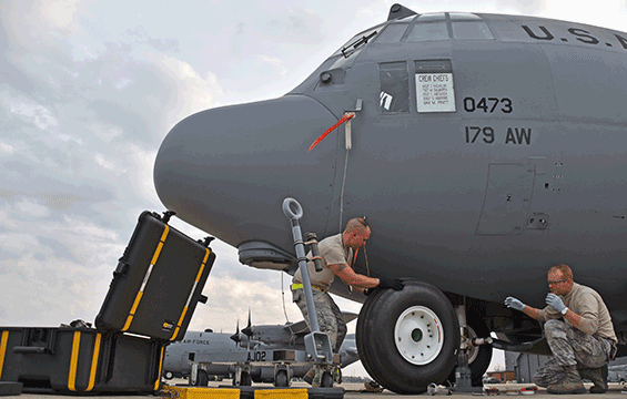 Master Sgt. Zac Michalski (left) and Tech. Sgt. Mark Dulworth change a tire on a C-130H Hercules.