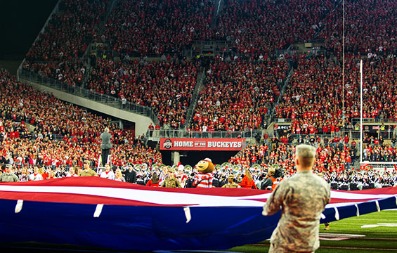 Members of the Ohio National Guard display a large American flag across the OSU football field.