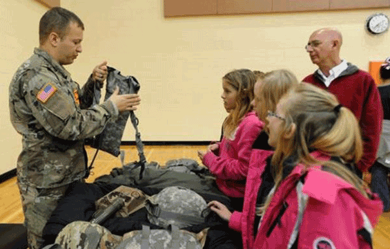 Staff Sgt. Dustin Bowshier (left) of the 52nd Civil Support Team talks about a Soldier’s individual equipment with students.