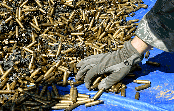 A security forces specialist assigned to the 180th Fighter Wing separates 7.62 mm casings from chain links after firing crew-served weapons.