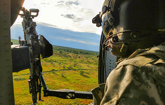 Spc. Alphonso Grant, a UH-60 Black Hawk helicopter crew member with Company B, 1st Battalion, 137th Aviation Regiment, waits to engage targets with a M240C machine gun from the door of a Black Hawk.