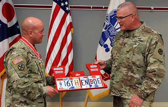 Command Sgt. Maj. Steven Shepherd (right) presents Col. Ben C. Capriato Jr. with a customized gift.