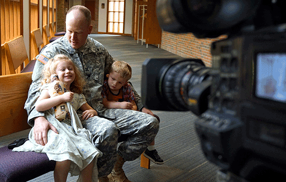 Capt. Anthony Vogel, a Soldier with the Ohio National Guard’s 174th Air Defense Artillery Brigade, and his children sit for an interview.