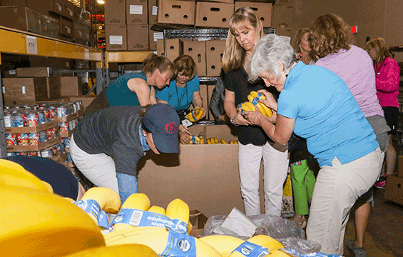 The spouses of more than 20 state adjutants general from across the country perform volunteer work stocking food items at the Mid-Ohio Foodbank.