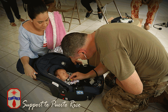 Staff Sgt. Matthew Crabtree performs a medical assessment on an infant less than one month old.