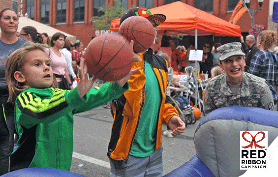 Children throwing basketballs in game with guard memebr watching.