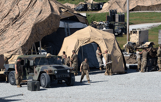 Tent camp with humvee in front and Soldiers working around on set-up.