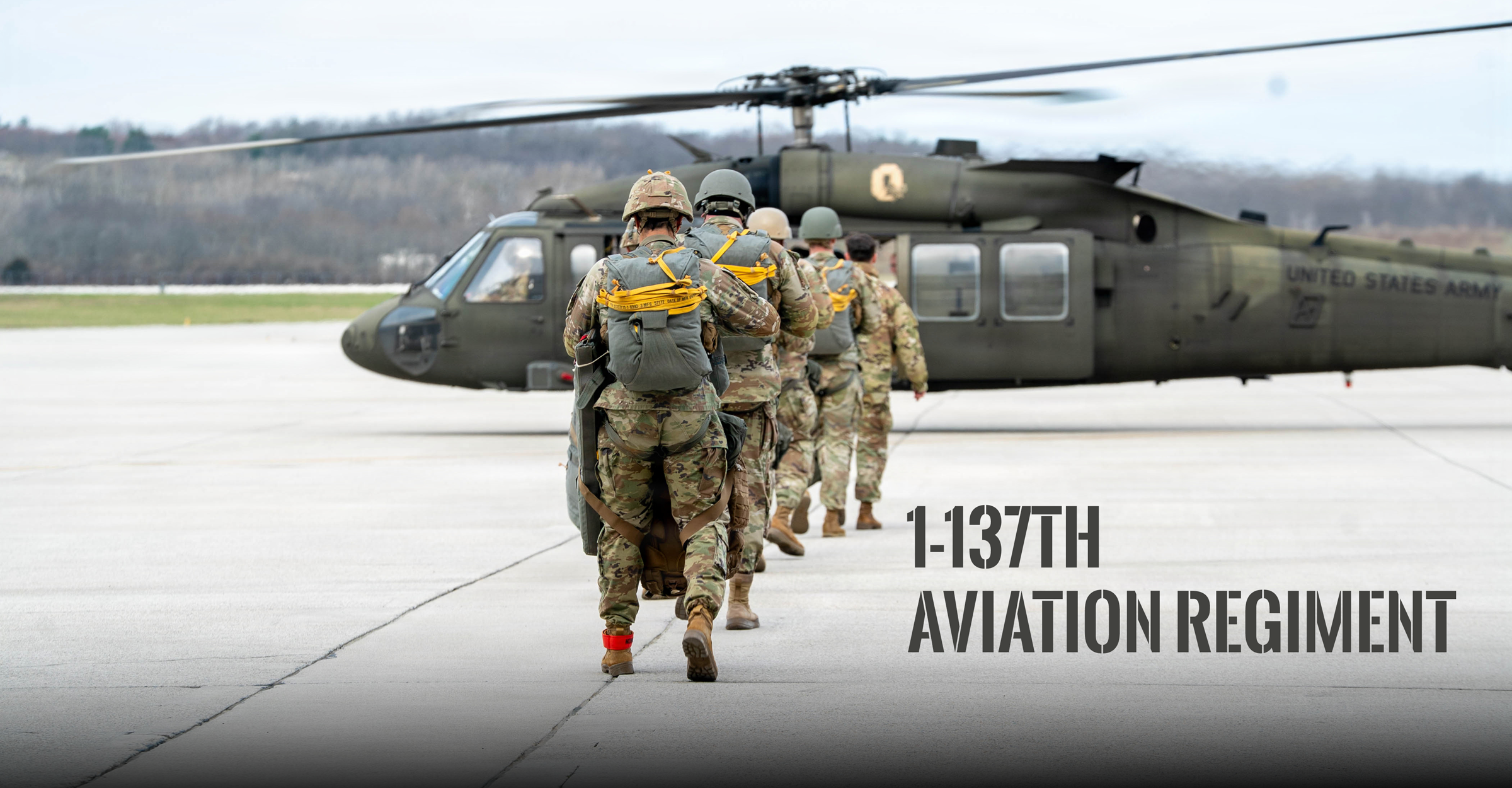 Soldiers line up facing a UH-60 Black Hawk helicopter