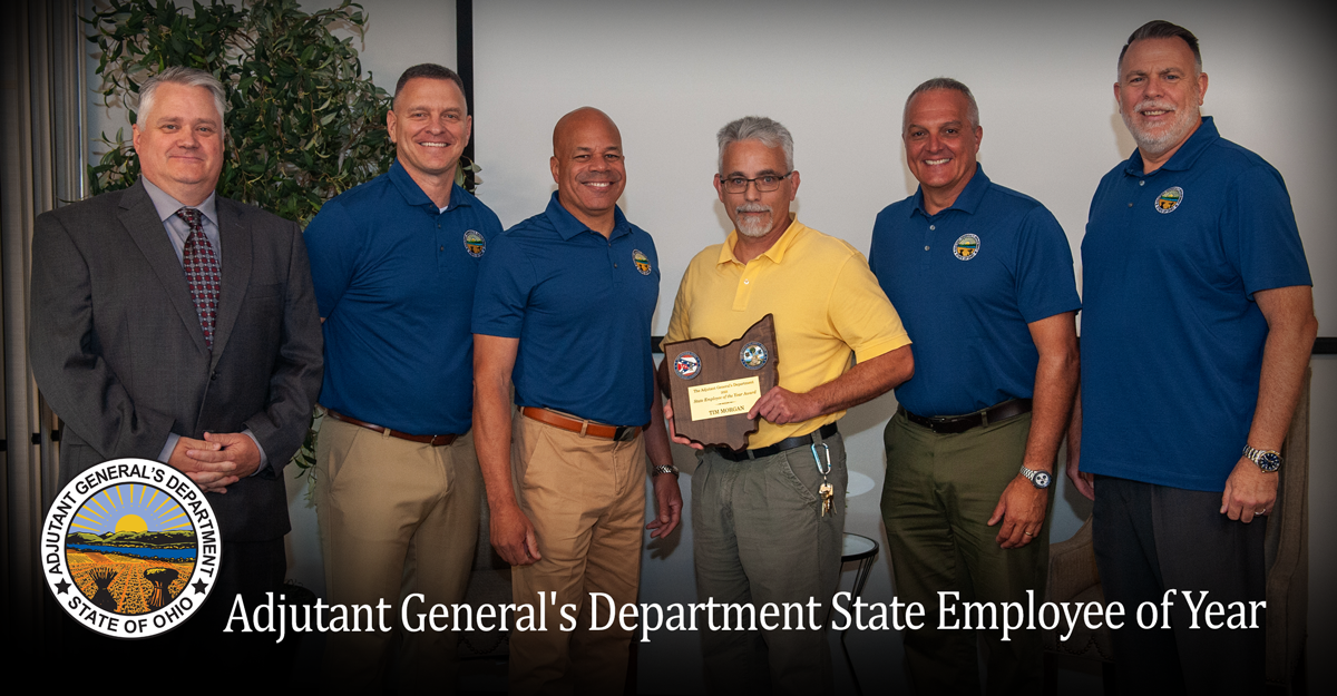 Group shot of ONG leadership with Employee of the year holding plaque.