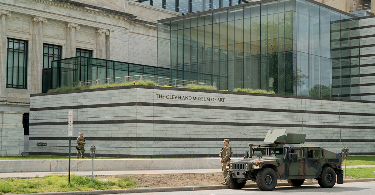 Soldiers stand guard outside museaum with humvee on street