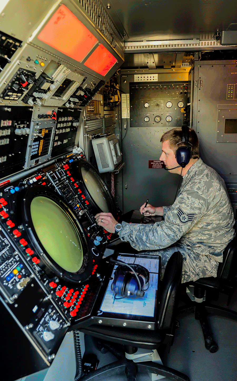 Airman looking at screens inside aircraft.