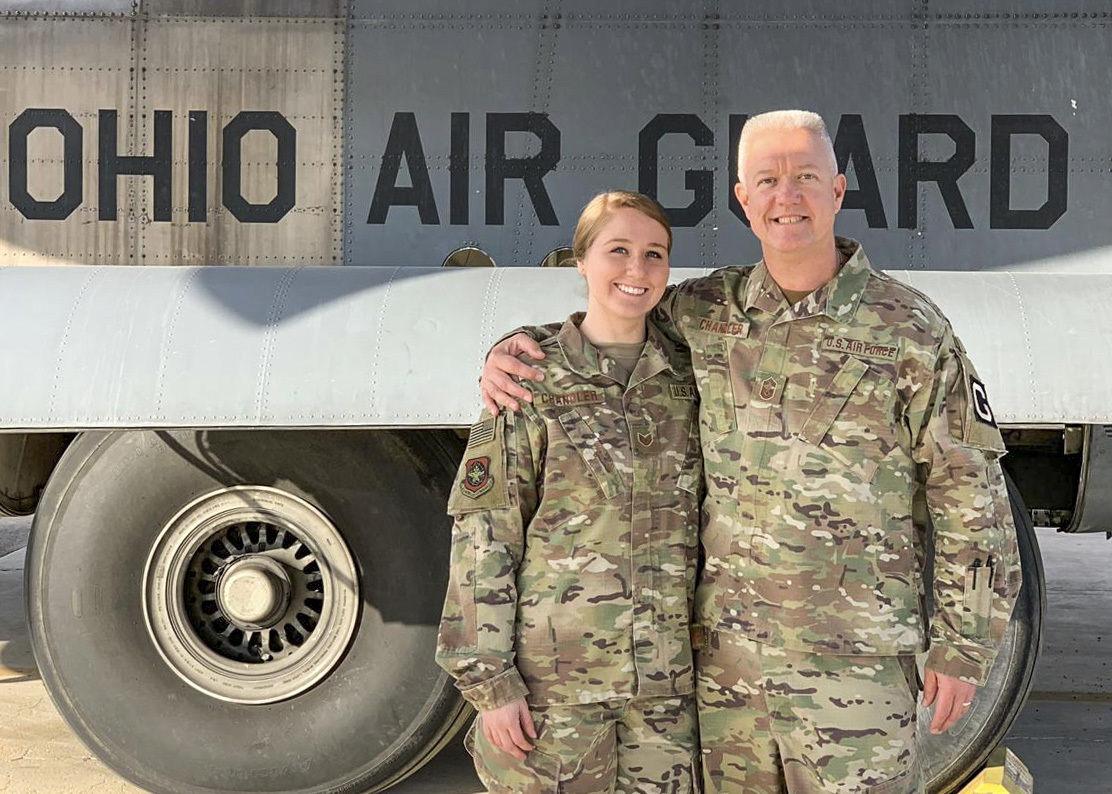 Chief Master Sgt. Ralph Chandler and Staff Sgt. Madison Chandler stand arm in arm in fron tof Ohio Air Guard aircraft.