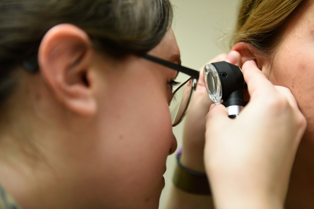 Doctor looks into patient's ear.