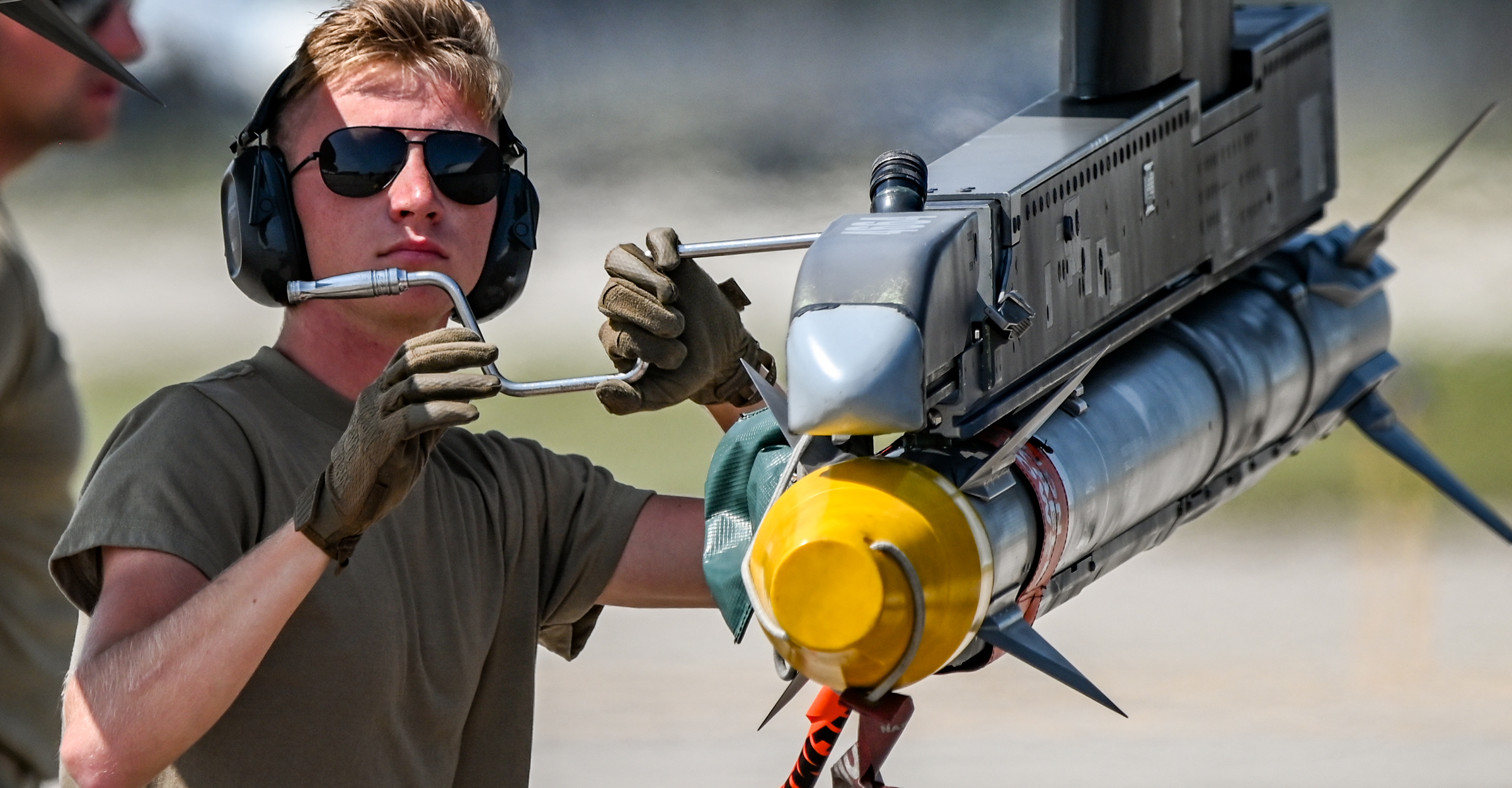 A weapons loader prepares an F-16C Fighting Falcon for takeoff