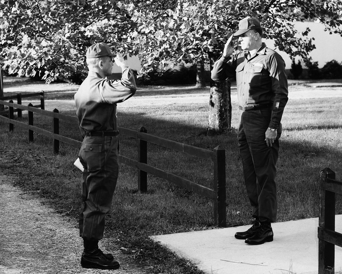 Black and white photo of first sergeant saluting squadron commander.