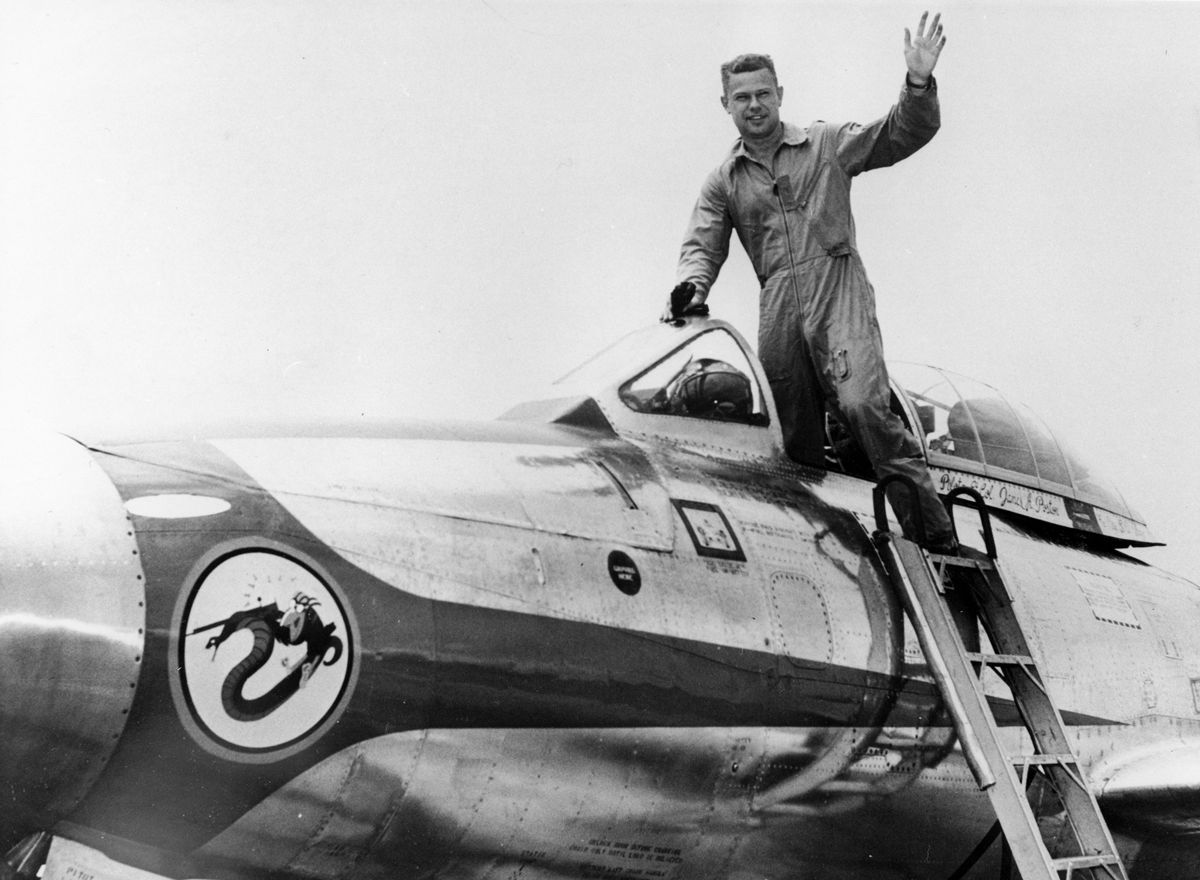  Black and white photo of pilot exiting jet. 