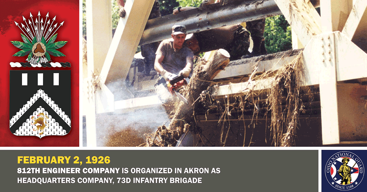 1998 photo: Spc. William Phelps of Company B, 112th Engineer Battalion, uses a chain saw to clear a fallen tree from a bridge