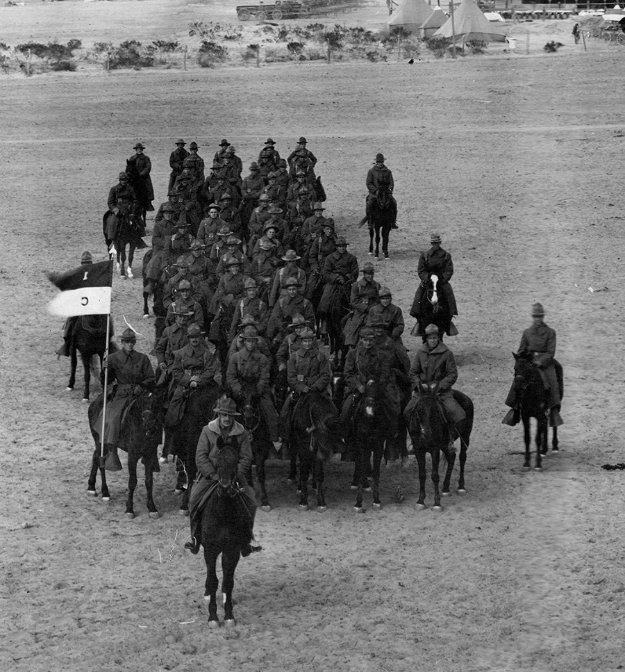 Black and white print of squadron riding forward on horses.