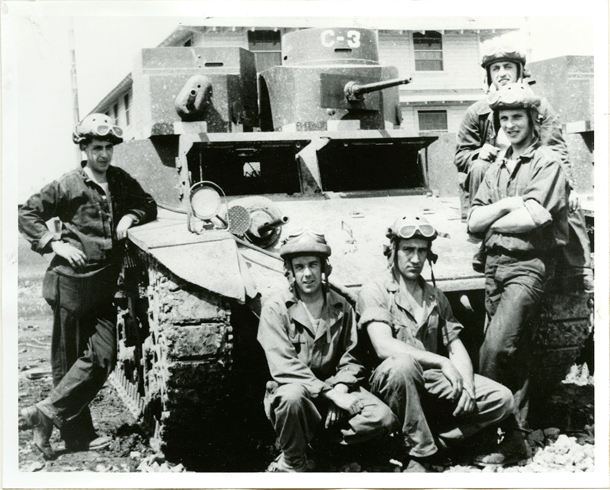Black and white photo from 1941 of Soldiers standing around a tank.