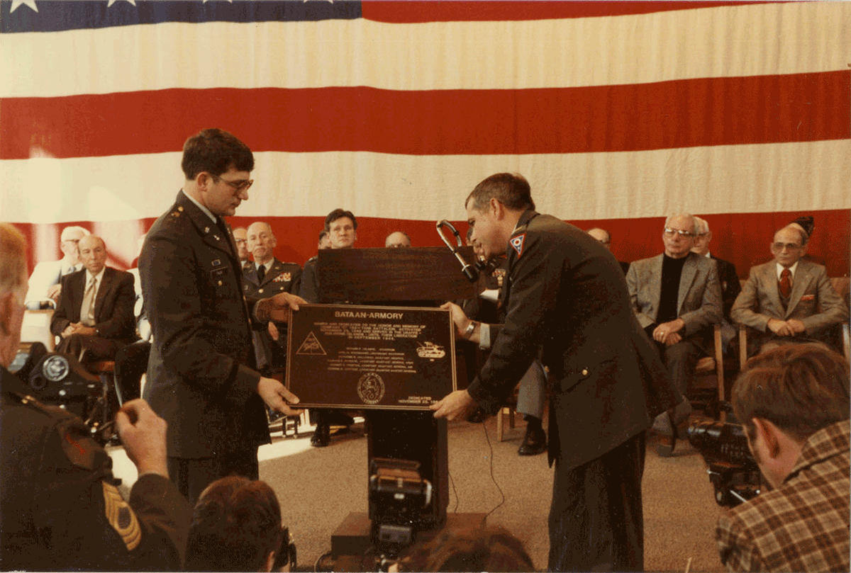 Color photo of Soldier accepting plaque at podium.