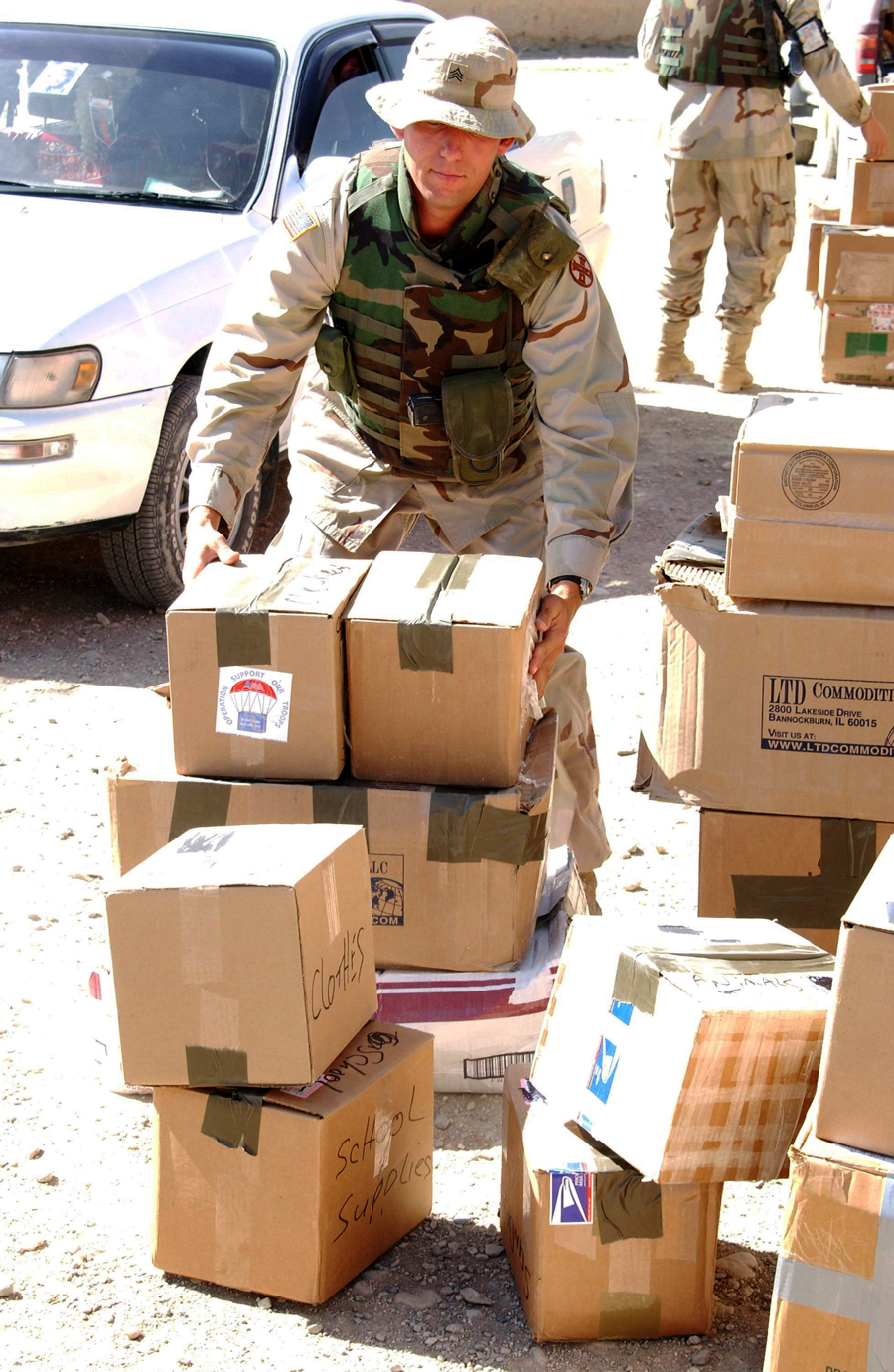 Soldier unpacks pallet of boxes.