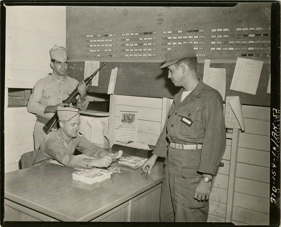 Black and white photo 1952 of Soldier being paid.