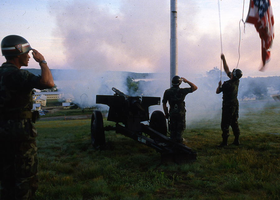 Color photo of Soldier saluting the raisinf of the American flag after canon shot in 1985.