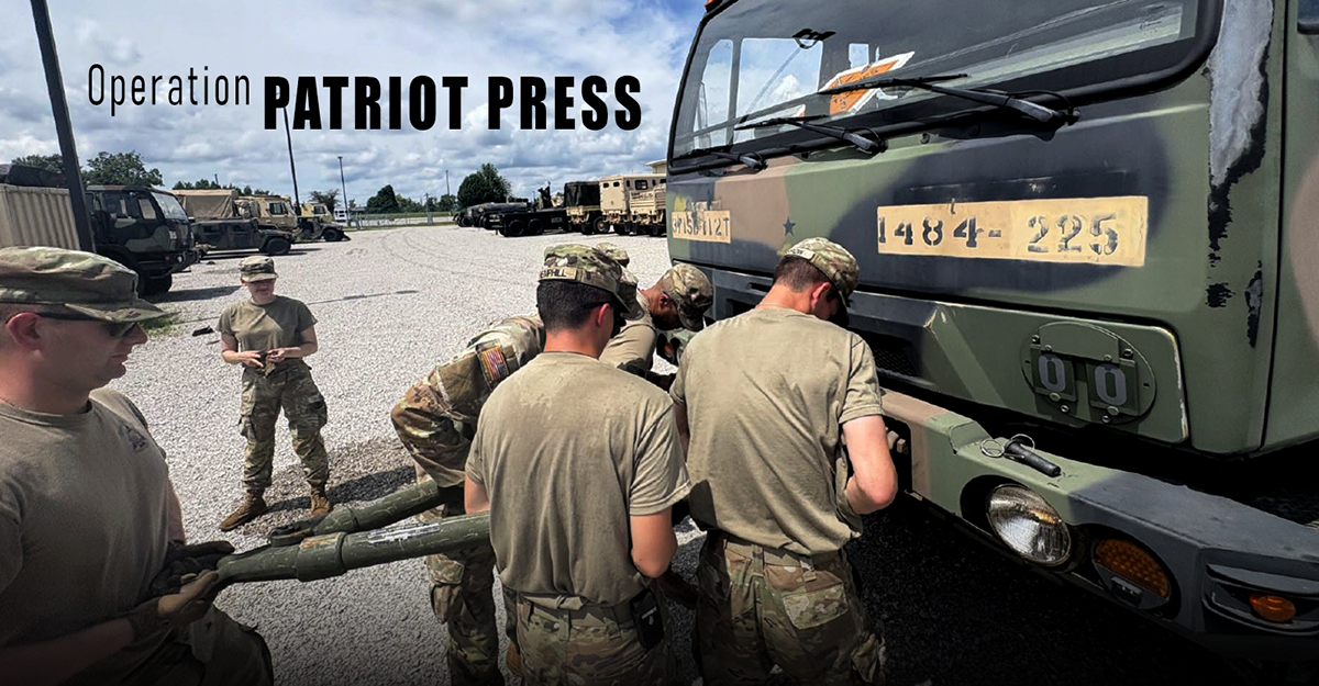 Soldiers work on the front of an army vehicle