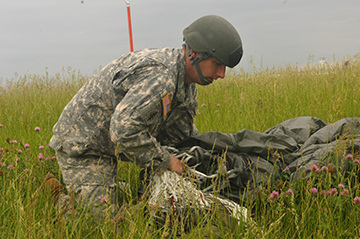 Maj. Jarrod Hoose, commander of Company B, 2nd Battalion, 19th Special Forces Group (Airborne), gathers his parachute after a parachute training jump, June 8, 2014, at Rickenbacker Air National Guard Base in Columbus, Ohio. More than 30 members of the Special Forces unit were conducting a jump into the drop zone at Rickenbacker as part of their weekend drill training.