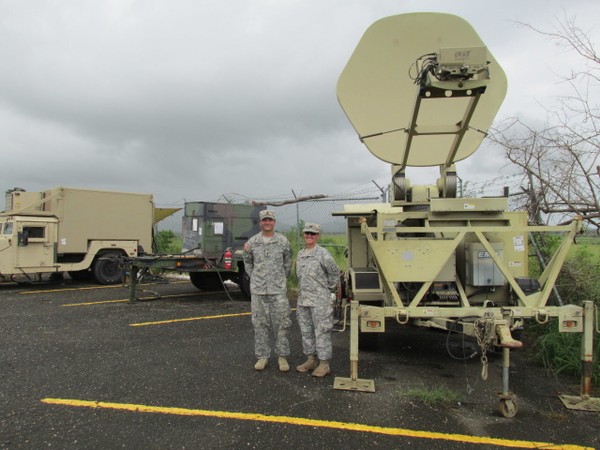 Capt. Denise Stewart, right, of Johnstown, Ohio, commander of the National Guard's 137th Signal Co., and Lt. Phil Franze, of Brunswick, stand next to a satellite dish uplink and other communications gear designed to connect nearly 40 military organizations and some government agencies doing disaster relief in Puerto Rico. There are six such locations operated by the unit in Puerto Rico, including this one at the Puerto Rican National Guard's Camp Santiago. (Brian Albrecht/The Plain Dealer)

