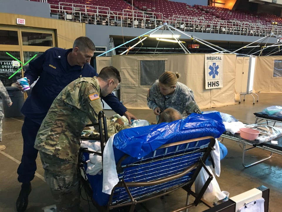 Two members of the Ohio National Guard's 285th Medical Co. (Area Support) and a worker from the U.S. Public Health Service tend to a patient in a Ponce basketball arena converted to a temporary treatment center for patients who aren't sick enough to go into a hospital, but still need care they can't receive at home or in a shelter.