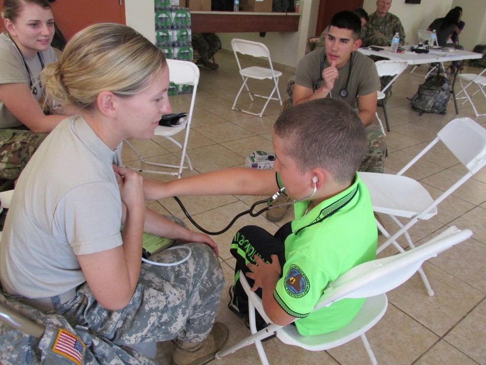 A Puerto Rican boy tries out a stethoscope on Spec. Skylar Corum of the Ohio National Guard's 285th Medical Co. (Area Support) during a visit to a temporary medical clinic staffed by Guard members in Jayuya, Puerto Rico. (Brian Albrecht/The Plain Dealer)
