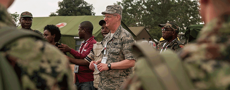 Maj. Gen. Mark E. Harris stands among Angolan Soldiers at medical camp.