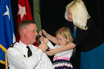 Karen Stivers helps her daughter Sarah affix new shoulder boards on the uniform of her father, Brig. Gen. Steven E. Stivers, during his promotion ceremony. 