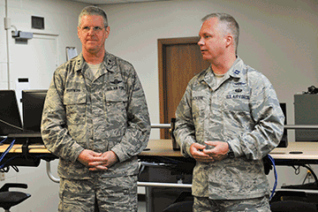 Maj. Gen. Mark E. Bartman (left), Ohio adjutant general, receives an update from Capt. Scotty Jackson, team lead for the stateside group during Cyber Tesla.