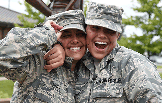 Twin sisters hugging in uniform.