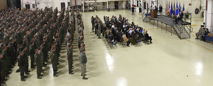 Members of the 179th Airlift Wing stand at attention in balcony shot in hangar.