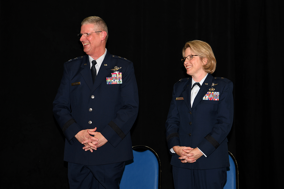 Col. Rebecca L. O’Connor stands with Maj. Gen. Mark E. Bartman on stage.
