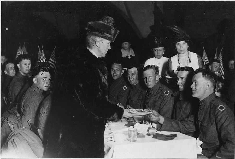 Mother serves Soldiers at tables.