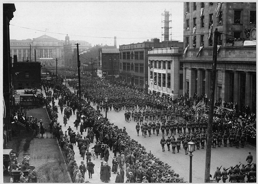 Historic black and white photo of parade from 2nd story building.