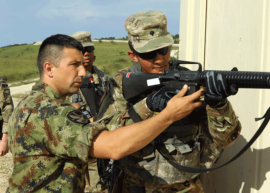 A Serbian Military Operations on Urban Terrain (MOUT) instructor trains Soldier for using weapon.