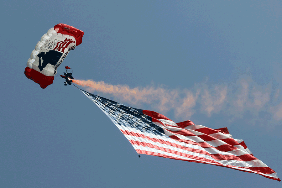 Parachuter and American flag in the sky.