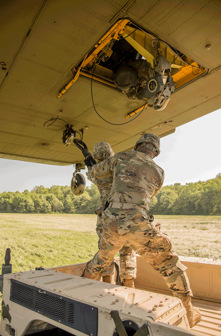 Soldiers connect load beneath a CH-47 Chinook helicopter.