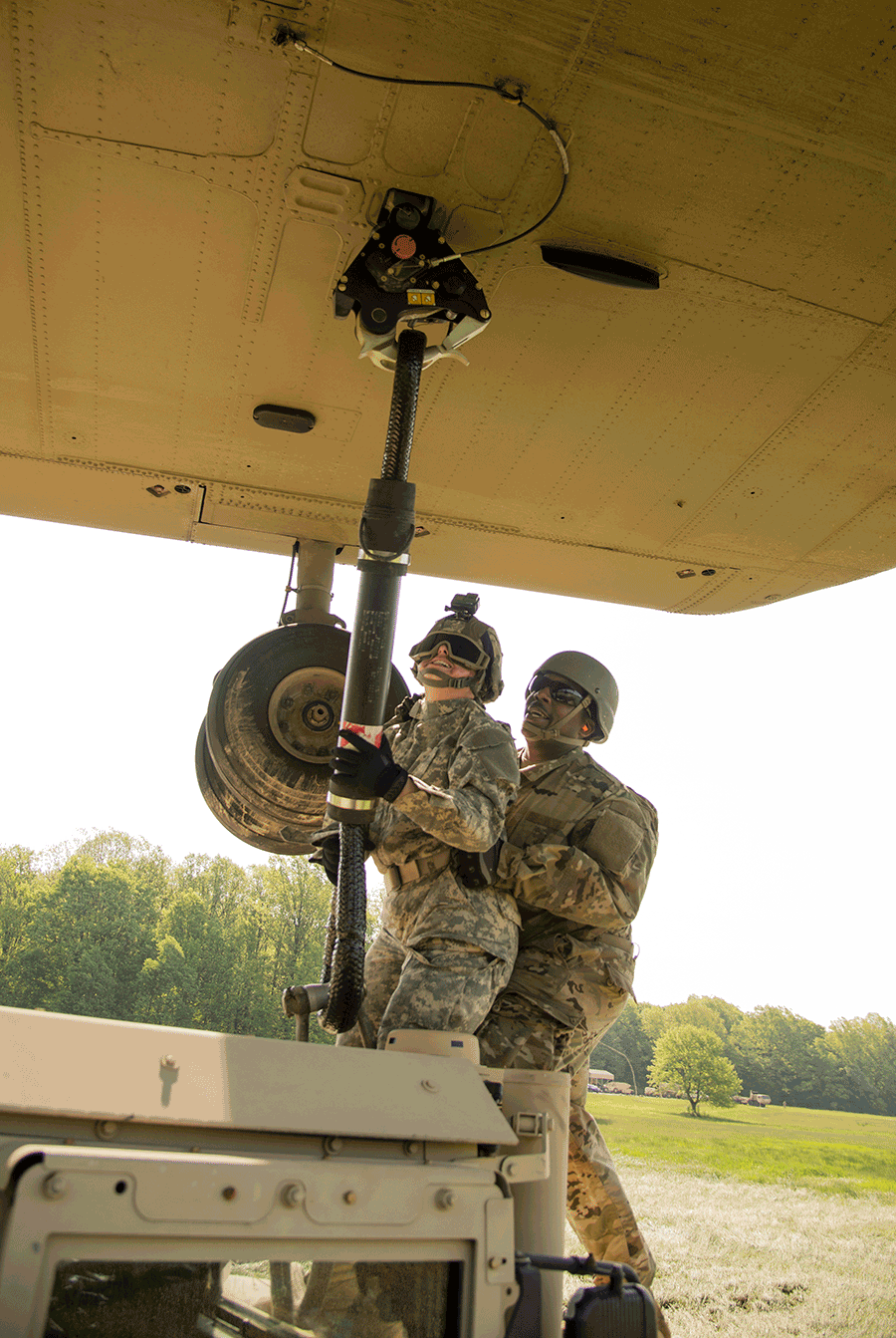 Soldiers connect loads beneath a CH-47 Chinook helicopter.