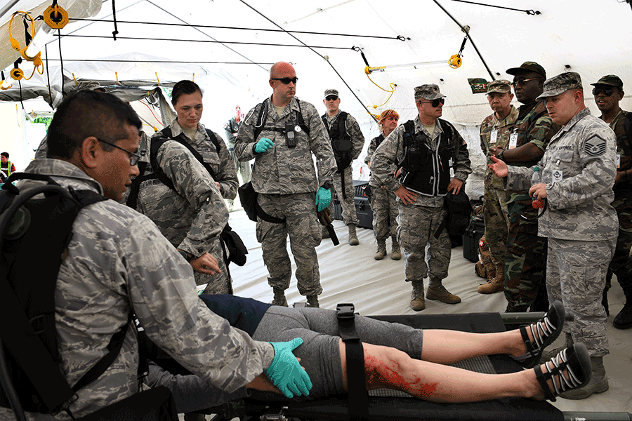 Airmen demonstrate casualty practices inside casualty tent.