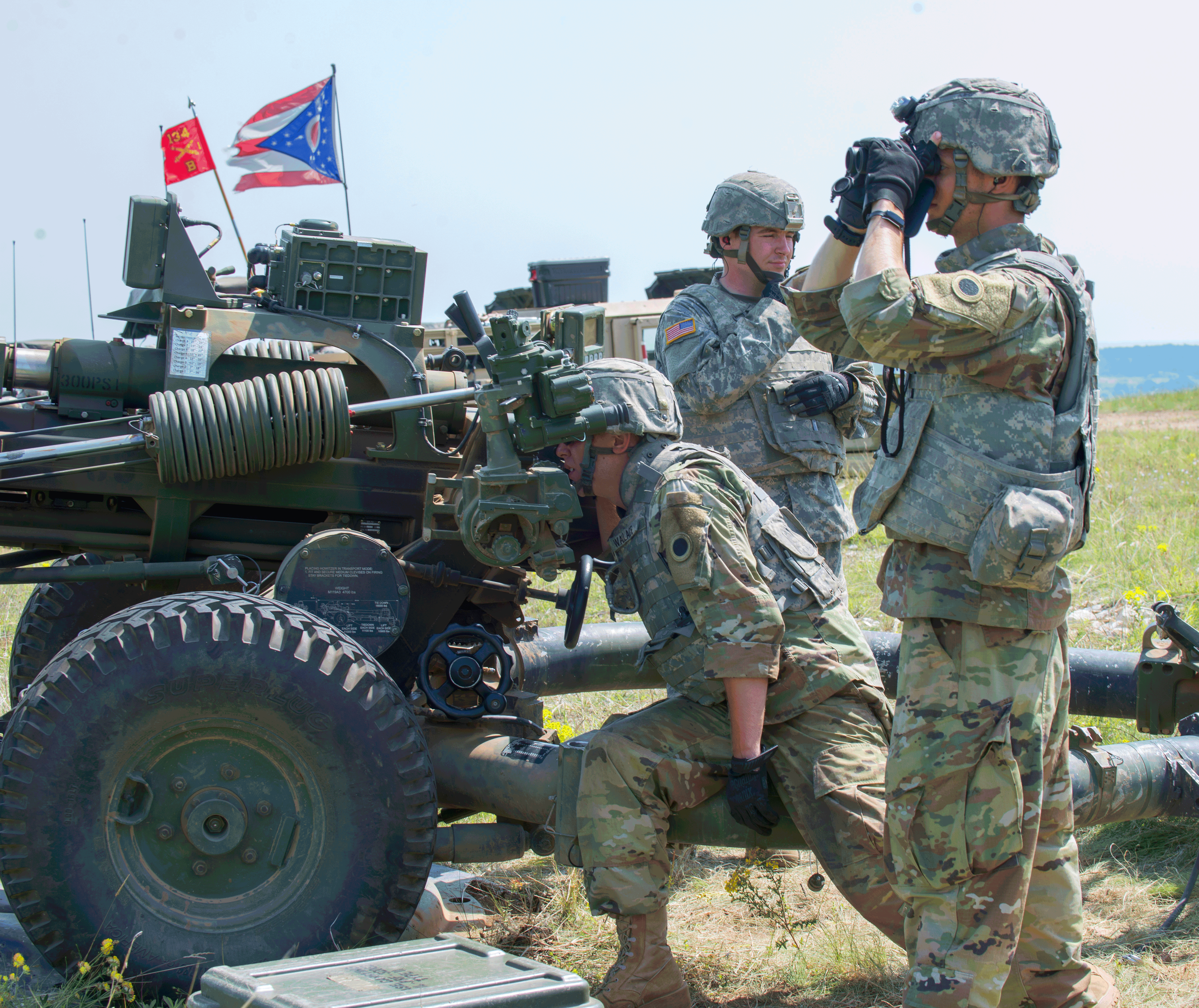 Soldiers fire M119A3 howitzer.