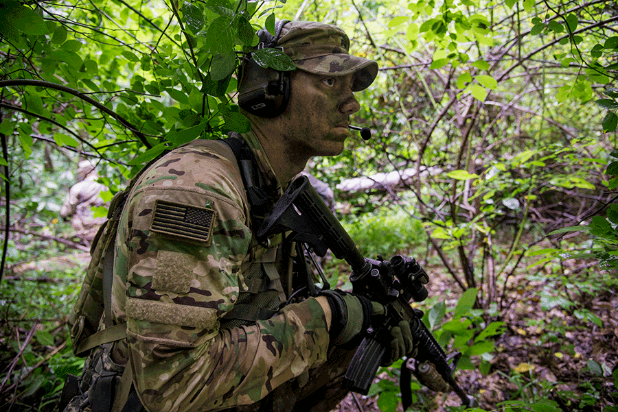 Soldier in camo in forest.
