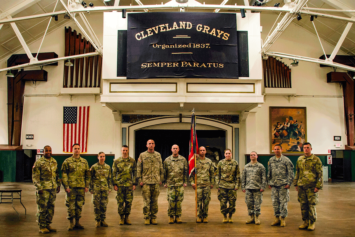 Members of the 112th Engineer Battalion stand for a photograph with their organizational colors on the drill floor of the Cleveland Grays Armory Museum.